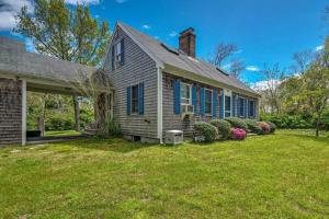an old house with blue windows and a yard at Stay On The Cape Vacation Rentals: Book Eastham Plenty Of Room For Entire Family in Eastham