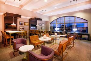 a restaurant with tables and chairs and a large window at Sheraton Baltimore Washington Airport - BWI in Linthicum Heights