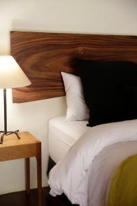 a bedroom with a bed with a wooden headboard and a lamp at Casa9 Zocalo in Mexico City