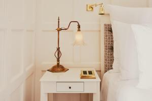 a bedside table with a lamp next to a bed at At Sloane in London