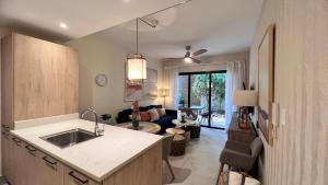 a kitchen and a living room with a couch at Apartamento Punta Cana w/Pool & Beach in Punta Cana