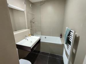 uma casa de banho com um lavatório, uma banheira e um WC. em Appartement 3 personnes quartier Chartrons em Bordeaux