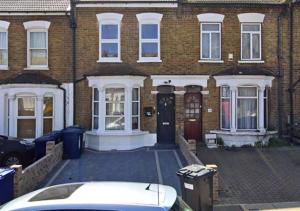 ein weißes Auto, das vor einem Backsteinhaus parkt in der Unterkunft Aisiki Apartments at Stanhope Road, North Finchley, Airconditioned 3-Bedroom and 2-Bathroom, Pet-Friendly Duplex Flat, King or Twin Beds, with Free Wi-Fi in Finchley