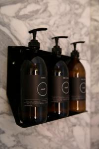three bottles of soap on a shelf in a bathroom at Casa9 Zocalo in Mexico City