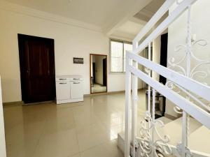 Habitación grande de color blanco con escalera y cocina. en Maison fonctionnelle idéalement située à Dakar en Dakar