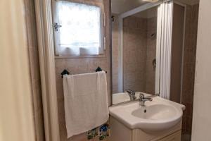 a white bathroom with a sink and a mirror at In the small heart of Florence + Corte privata+ WiFi+AC in Florence