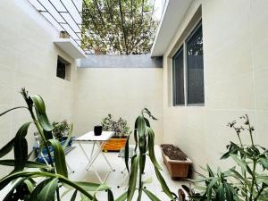 une chambre avec des plantes, une table et une fenêtre dans l'établissement Maison fonctionnelle idéalement située à Dakar, à Dakar