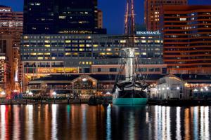 un barco está atracado frente a una ciudad por la noche en Renaissance Baltimore Harborplace Hotel, en Baltimore