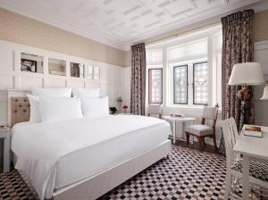- une chambre avec un grand lit blanc et un bureau dans l'établissement At Sloane, à Londres