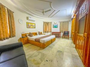 a bedroom with a bed and a desk and a chair at RESORT FARM VILLA in Bhuj