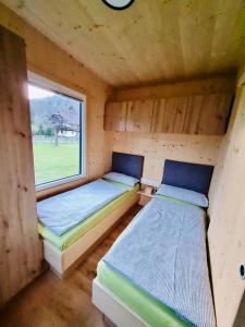 two beds in a small room with a window at Mobile Homes Camping Reiter in Greifenburg