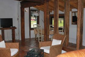 a living room with a table and chairs and a television at Villa de 2 chambres avec piscine partagee terrasse et wifi a Pontonx sur l'Adour in Pontonx-sur-lʼAdour