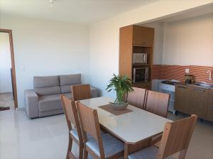 kuchnia i jadalnia ze stołem i krzesłami w obiekcie Apartamentos Beira Mar w mieście Laranjal