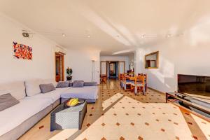 a living room with a white couch and a table at Emma Beachfront Apartment in Port de Pollensa