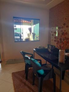 comedor con mesa, sillas y espejo en Verdes Hostel Palmas-TO, en Palmas