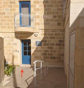 a building with a blue door and a balcony at Sea Holly Gozo in Nadur