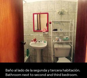 a bathroom with a sink and a toilet and a mirror at Alamos stay in Lima