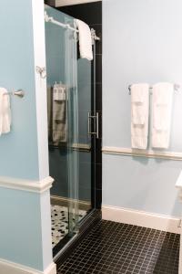 uma casa de banho com um chuveiro e uma porta de vidro em The Morehead Inn em Charlotte