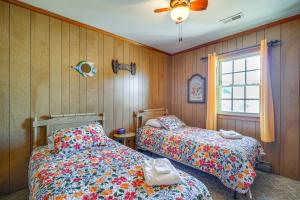 two beds in a room with wooden walls and a window at Kill Devil Hills Vacation Rental, Walk to Beach! in Kill Devil Hills