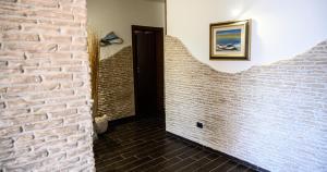 a hallway with a brick wall and a door at Risa Apulia in Torre Lapillo