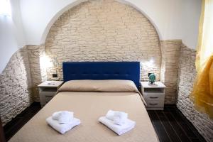 a bedroom with a bed with two white towels at Risa Apulia in Torre Lapillo