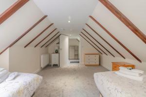 a attic bedroom with white walls and wooden beams at Cairngorms Cottage in Cray