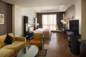 a hotel room with a bed and a living room at Crowne Plaza Al Khobar by IHG in Al Khobar