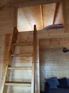 a loft bed in a log cabin with wooden walls at 38 m Sommer-Blockhäuschen im Spreewald in Heideblick