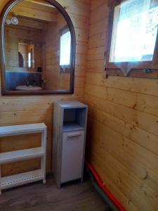 a bathroom with a mirror and a sink in a cabin at 38 m Sommer-Blockhäuschen im Spreewald in Heideblick