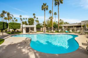 una gran piscina con sillas y palmeras en Palm Springs Condo with Pool Access Near Downtown!, en Palm Springs