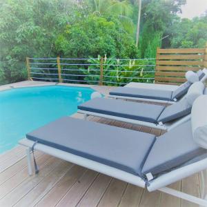 two lounge chairs on a deck next to a swimming pool at Appartement de 2 chambres avec terrasse et wifi a Gros Morne in Gros-Morne