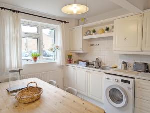 - une cuisine avec une table et un lave-linge dans l'établissement Family Home in Rustington, West Sussex, à Rustington