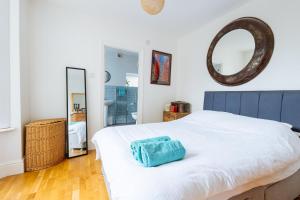 a bedroom with a white bed and a mirror at Comfy 1-Bed Apartment in London in London