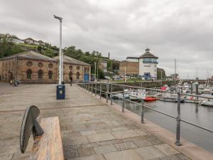 a dock with a bench and boats in a harbor at 5C Queen Street in Whitehaven