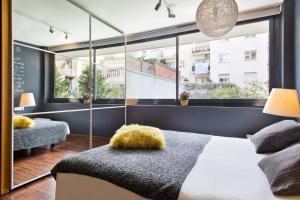 1 dormitorio con cama y ventana grande en Barcino Inversions - Modern Duplex with Private Garden and Swimming Pool, en Barcelona