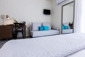 a bedroom with a white bed and a couch at Lemon Tree House in Karpathos