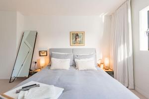 a white bedroom with a large bed with two pillows at The Modern Cottage in Whitstable