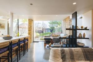 uma cozinha e sala de estar com um balcão e um bar em The Modern Cottage em Whitstable