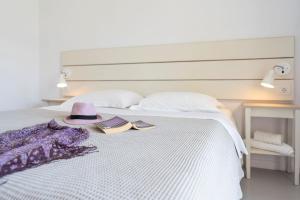 a bed with a hat and two books on it at Beach Break Rhodes in Faliraki