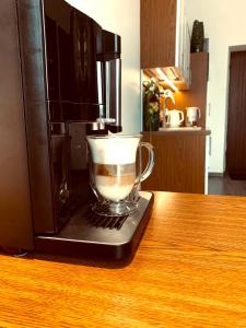 filiżankę kawy siedzącą na kuchence mikrofalowej w obiekcie Nasze Kamienice Apartament Express Rzeszów Główny w mieście Rzeszów
