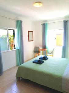 a bedroom with a bed with blue towels on it at Azimute Guest House in Aljezur