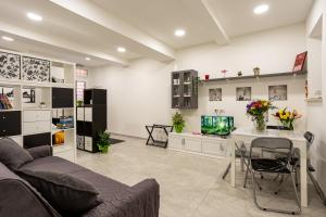 a living room with a couch and a table and a tv at Petite House Frascati in Frascati