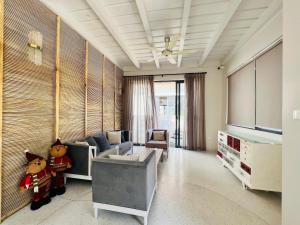 a living room with a couch and a tv at Villa de Lumiere - đô thị thượng lưu Swanbay, Đại Phước 330m2 với 6 phòng ngủ tiện nghi in Nhơn Trạch