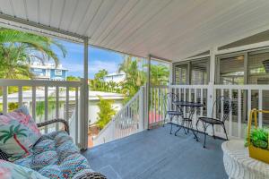 a porch with a couch and a table and chairs at Island Hideaway steps to beach dock Bridge St in Bradenton Beach