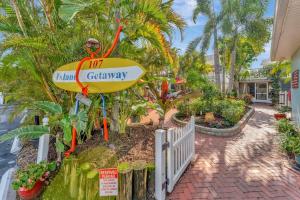 a sign for the island getaway with a surfboard at Island Hideaway steps to beach dock Bridge St in Bradenton Beach