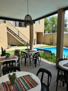 a patio with tables and chairs and a pool at Los Martínez Apart in Paganini