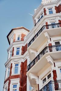 ein hohes weißes Gebäude mit Balkonen darauf in der Unterkunft At Sloane in London
