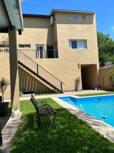 a bench in front of a house with a swimming pool at Los Martínez Apart in Paganini +4 photos