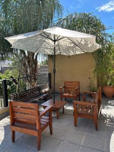 a group of benches sitting under an umbrella at Los Martínez Apart in Paganini