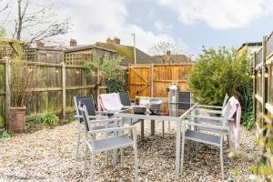 a garden with a table and chairs and a fence at Seascape in Whitstable